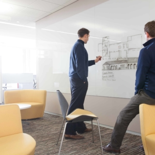 two colleagues using a Float wall-mounted glass board